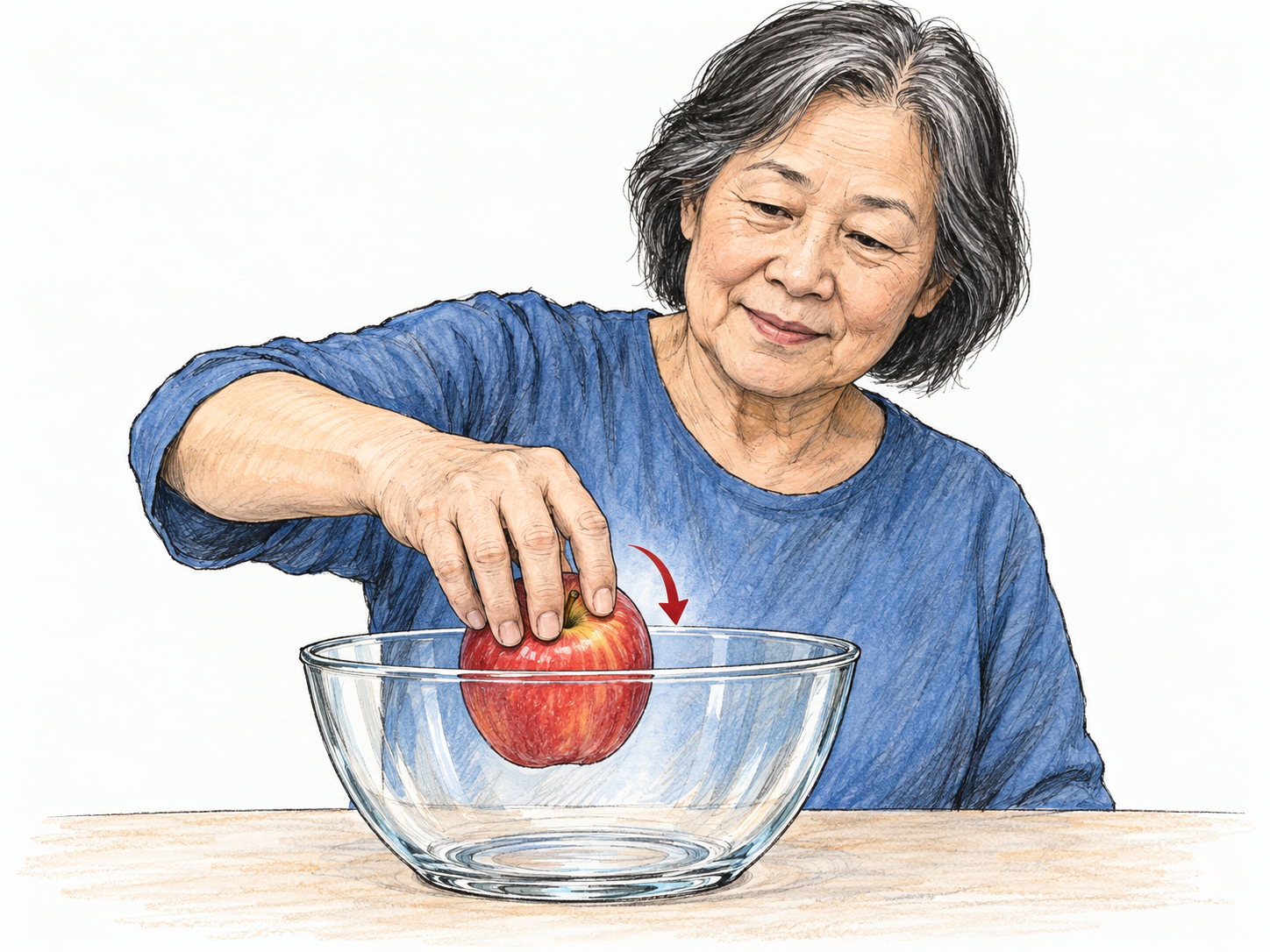An older woman lowers an apple through the open mouth of a clear glass bowl, with the apple visibly crossing the rim into the bowl.